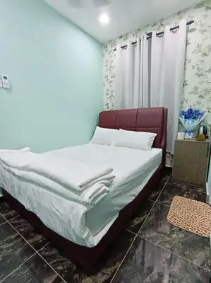 a bedroom with a bed with white sheets at SunStar Hotel in Kampong Batu Maung