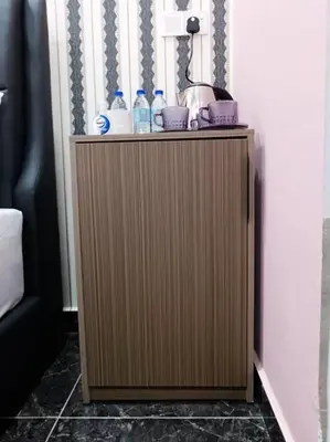 a wooden cabinet with two bottles of water on top at SunStar Hotel in Kampong Batu Maung