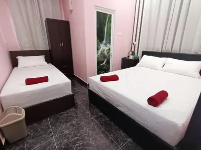 two beds in a room with red pillows on them at SunStar Hotel in Kampong Batu Maung