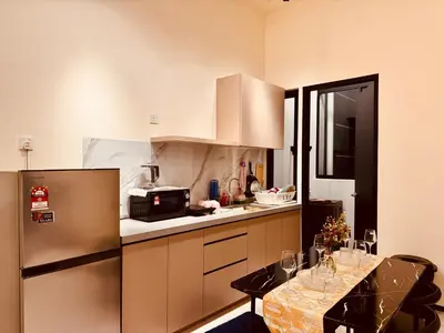 a kitchen with a refrigerator and a table with chairs at The Best Luxury suites Asia Spacious 3BR Sea View in Jelutong