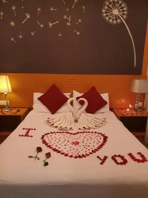 a bed with a white blanket with a peace sign on it at Cameron Nova Highlands Resorts II in Brinchang