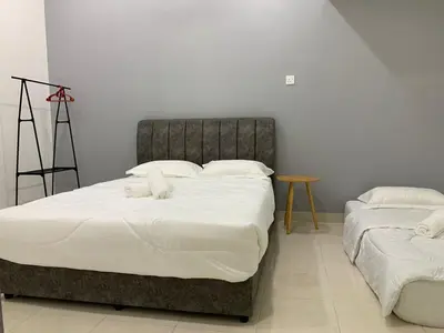 a bedroom with two beds with white sheets at Eco Homestay in Teluk Intan