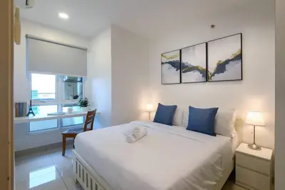 a bedroom with a large white bed with blue pillows at 2R2B Seaview Serenity 1 to 8pax Gurney Mansion One in George Town