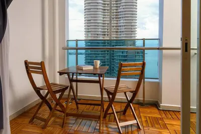 a table and two chairs in a room with a window at 2R2B Seaview Serenity 1 to 8pax Gurney Mansion One in George Town