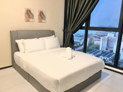 a bedroom with a white bed with a large window at Urban Suite Condominium By Blue Sky Holidays in Jelutong