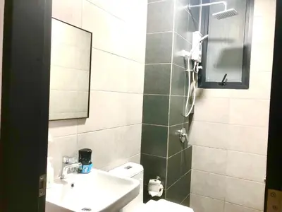 a bathroom with a sink and a toilet and a mirror at Urban Suite Condominium By Blue Sky Holidays in Jelutong