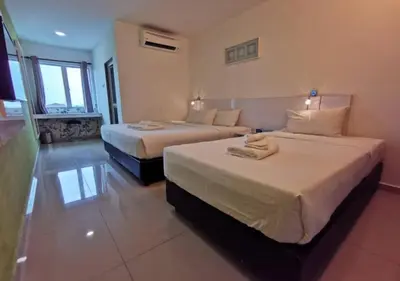 a hotel room with two beds and a window at Yew Boutique Hotel in Teluk Intan