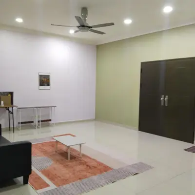 a large room with a ceiling fan and a table at Happy Raub Guest House in Raub