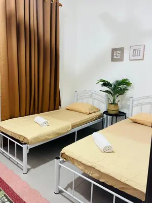 a room with three beds and a curtain at Casa Kita Homestay in Bandar Baharu