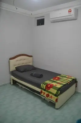 a small bed in a room with avertisement at Yim's Homestay in Kuala Kubu Baharu