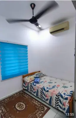 a bedroom with a bed and a ceiling fan at D'SQ Homestay in Tanjung Karang