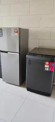 a refrigerator and freezer sitting next to a wall at Cozy Homestay in Ipoh