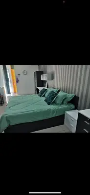 a bedroom with a bed with green sheets and pillows at Zaf's Stay in Kampong Malim Nawar