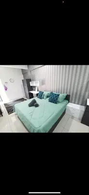 a bedroom with a green bed with blue pillows at Zaf's Stay in Kampong Malim Nawar
