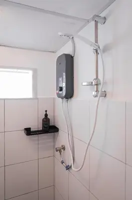 a shower in a bathroom with a tv on the wall at Aayu Seckchuan - 3 mins walk to Love Lane in George Town