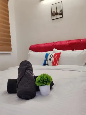 a stuffed animal on a bed with a plant on it at Busybee Breezy Stay Homestay in Ipoh