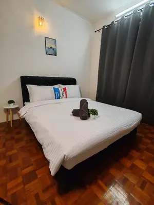a bedroom with a bed with a teddy bear on it at Busybee Breezy Stay Homestay in Ipoh