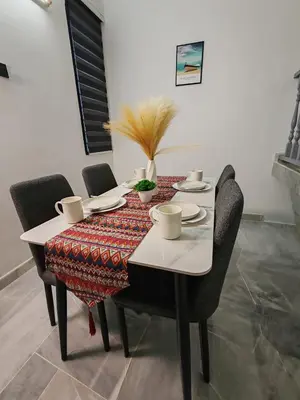 a dining room table with chairs and a white table cloth at Busybee Breezy Stay Homestay in Ipoh