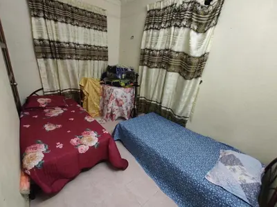 a room with a bed and a table with curtains at Penang Green Homestay Ground Floor in Permatang Pauh