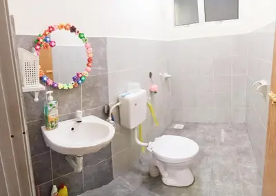 a bathroom with a toilet and a sink and a mirror at Ceq Atiah Homestay in Seri Iskandar