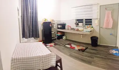 a small kitchen with a refrigerator and a counter at Ceq Atiah Homestay in Seri Iskandar