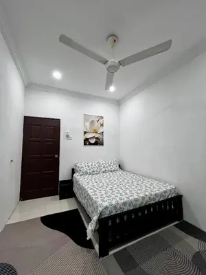 a bedroom with a bed and a ceiling fan at DH Homestay in Sungai Petani