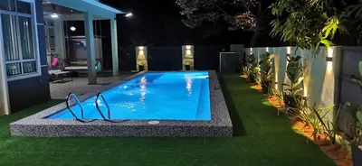a swimming pool in the middle of a yard at night at Teratak Dusun NadzYan in Bukit Selambau