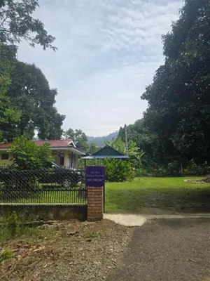 a sign in front of a house with a fence at Zue Rra Hidden Retreat in Kampong Kuala Chegar