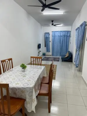 a dining room table and chairs in a living room at Amad Homestay in Kuala Lipis