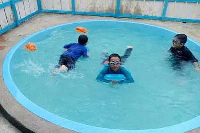 a group of children swimming in a swimming pool at Homestay Bendang Becah in Baling