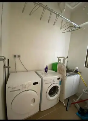 a laundry room with a washing machine and a washer at By The Sea Beach Front Sea view Apartment 3 in Batu Ferringhi
