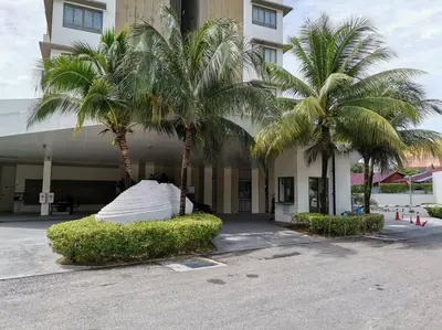 a building with palm trees in front of it at By The Sea Beach Front Sea view Apartment 3 in Batu Ferringhi