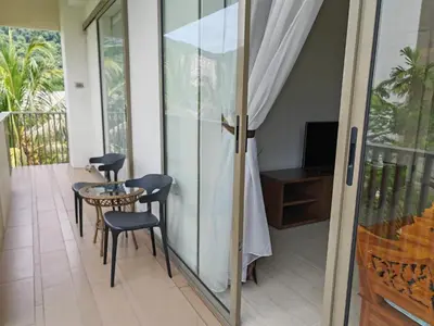 a room with a balcony with a table and chairs at By The Sea Beach Front Sea view Apartment 3 in Batu Ferringhi