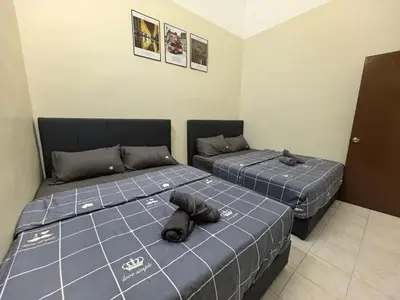 two beds in a room with two bedsitures at Padang Serai Premier Home in Kampong Dekeh