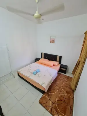 a bedroom with a bed in the corner of a room at Azam Homestay in Seri Manjung