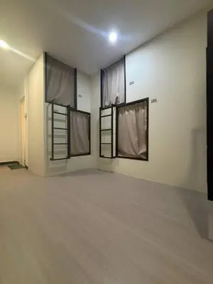 a room with three windows with curtains in it at Kek Lok Si Inn in Ayer Itam