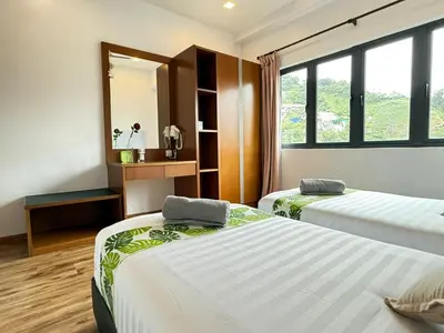two beds in a room with a mirror at The Retreat Mountain & Sunrise view Hilltop Hotel Apartment in Cameron Highlands in Cameron Highlands