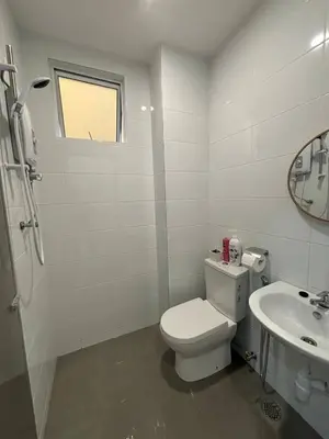 a white bathroom with a toilet and a sink at Trace Cozy Place in Teluk Intan