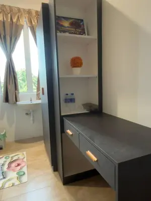 a bedroom with a black dresser and a window at Trace Cozy Place in Teluk Intan