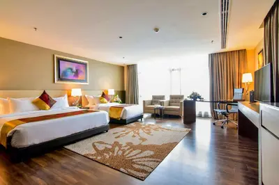 a hotel room with two beds and a living room at The Light Hotel Penang in Perai