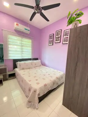 a bedroom with purple walls and a bed with a ceiling fan at Teratak Raffa Homestay in Kampong Tebing Rabak