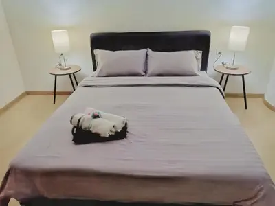 a large bed with two lamps on two tables at 118 Island Plaza Penang in Tanjong Tokong