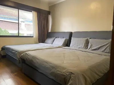 two beds in a bedroom with a window at Brinchang Cameron 2R2B 10 paxs Copthorne KeaFarm #15407 in Brinchang