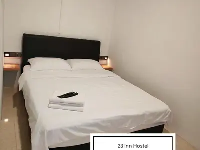 a bed with a remote control sitting on top of it at 23 Inn Queenbed Room with share bathroom in Simpang Ampat