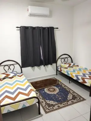 two beds in a room with black curtains at Arima Homestay A in Permatang Janggus
