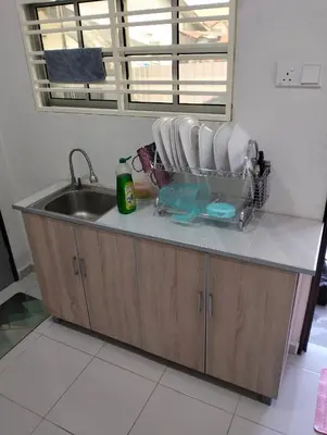 a kitchen counter with a sink and a mirror at Arima Homestay A in Permatang Janggus