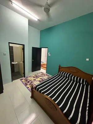 a bedroom with a bed in a room with a mirror at Homestay Warisan Taiping in Kampong Melayu Changkat Larah