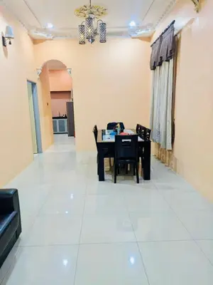 a dining room with a table and chairs on a white floor at Seri Changkat Homestay in Kampong Changkat Raja