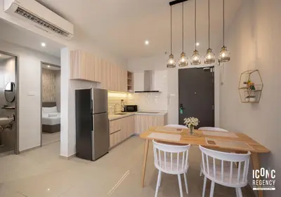 a kitchen with a wooden table and a refrigerator at Iconic Regency Service Residences, managed by Iconic Hotel in Bayan Lepas