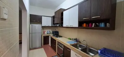 a small kitchen with a sink and a refrigerator at Big Mama's House in Tanah Rata